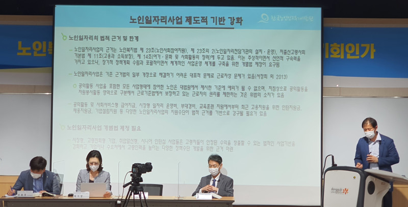 한국노인인력개발원 박경하 연구조사센터장이 빔 프로젝터 옆에서「복지와 노동시장 환경변화에 대응한 노인일자리 중장기 발전방안」을 주제로 발표하고 있으며, 앞에 세 명의 사람이 앉아있는 모습