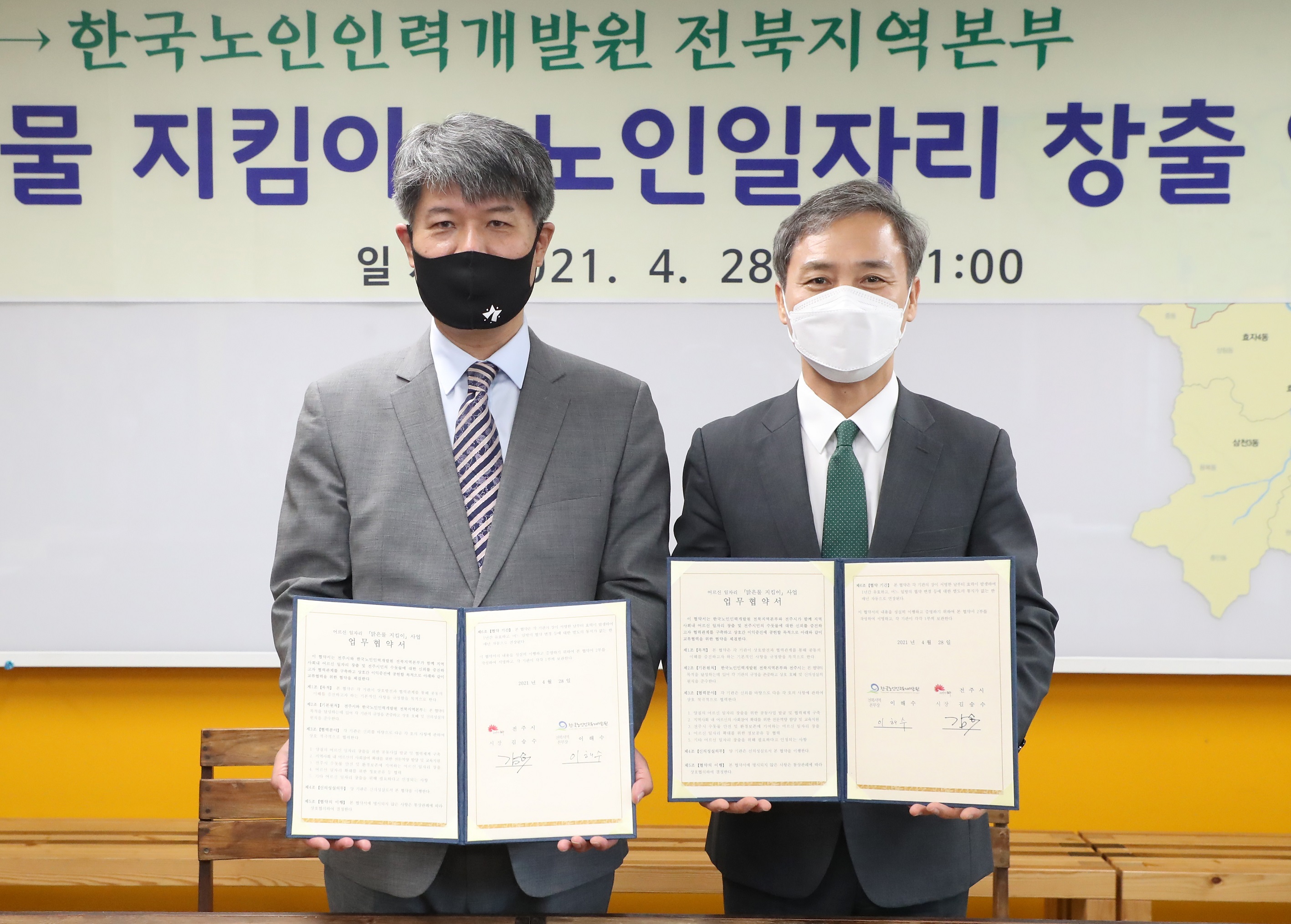 한국노인인인력개발원 전북지역본부 이해수 본부장(사진 좌측)과 전주시 김승수 시장(사진 우측)이 협약서를 들고 정면을 바라보며 서있는 모습
